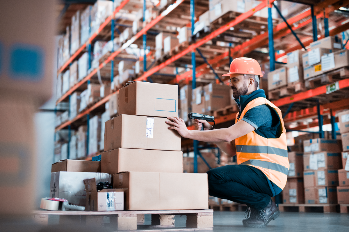 Warehouse worker taping boxes on a pallet